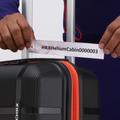 Black cabin suitcase handle label on white tag, with orange zipper trim
