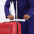 Small cabin suitcase being opened, red shell with black zipper trim and carry handles