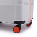 White hard-shell suitcase corner with black wheel and red rim accents.