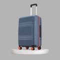 Blue hard-shell check-in suitcase angled view with red edge trim and rolling wheels