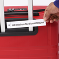 Red medium check-in suitcase: open front, luggage tag label, zipper track visible