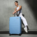 Blue hardside check-in suitcase with wheels and telescopic handle