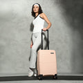 Small cabin suitcase in peach with telescopic handle and 8 spinner wheels