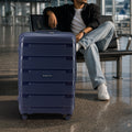 Blue large check-in trolley with hard-shell panels, telescopic handle, and four spinner wheels.