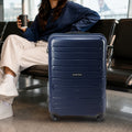 Dark blue 4-wheel polypropylene trolley with telescopic handle, in travel lounge setting