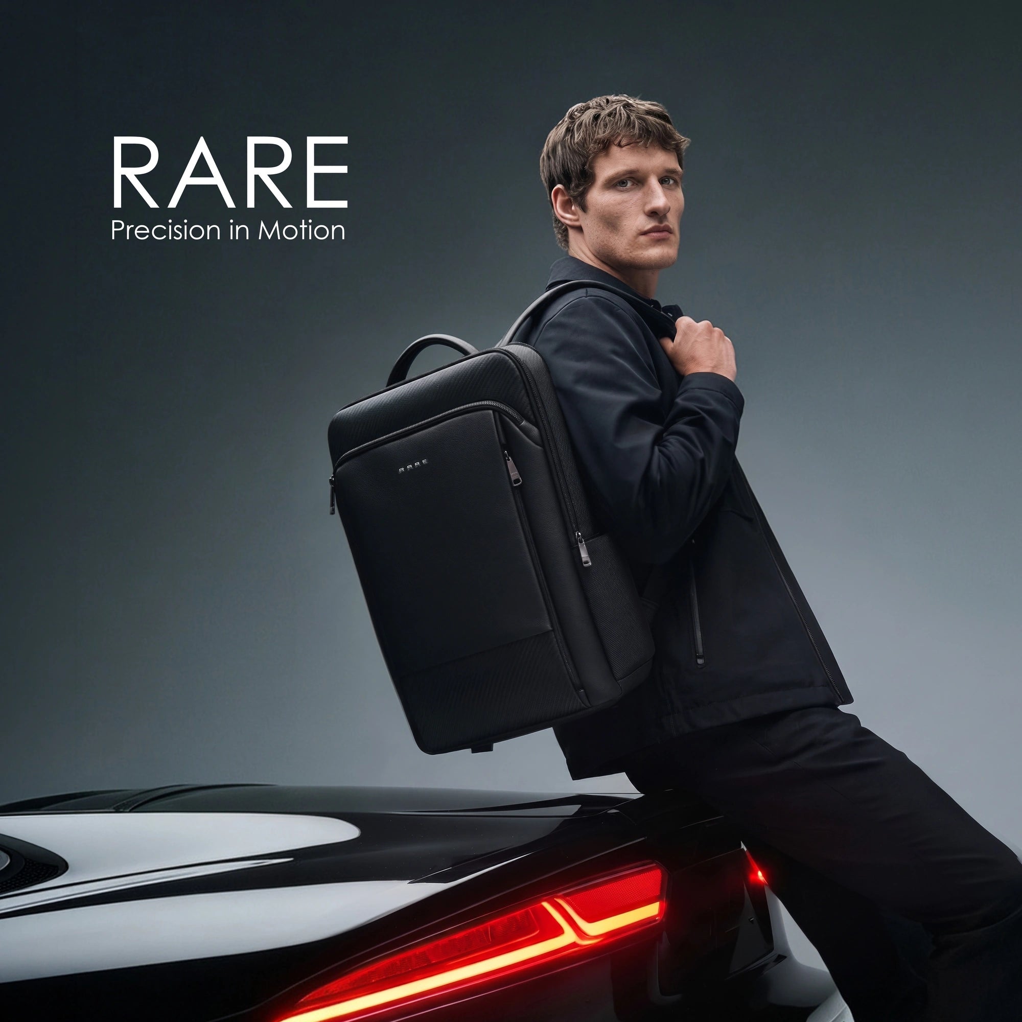 Black backpack worn by person, showing front panel and padded shoulder straps.
