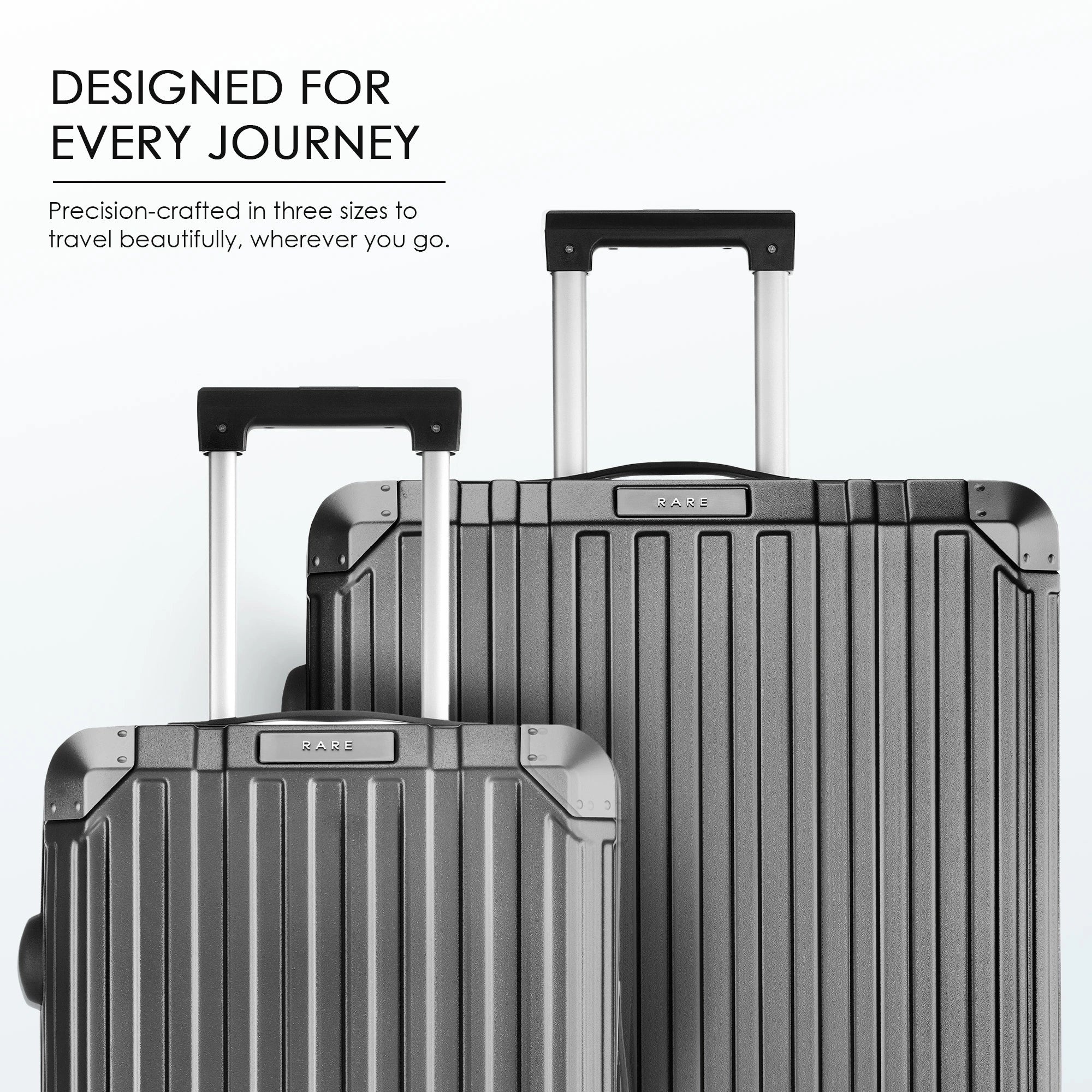 Two charcoal grey polycarbonate suitcases with telescopic handles and ridged front
