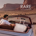 Silver medium suitcase open in car trunk with telescopic handle and compartments