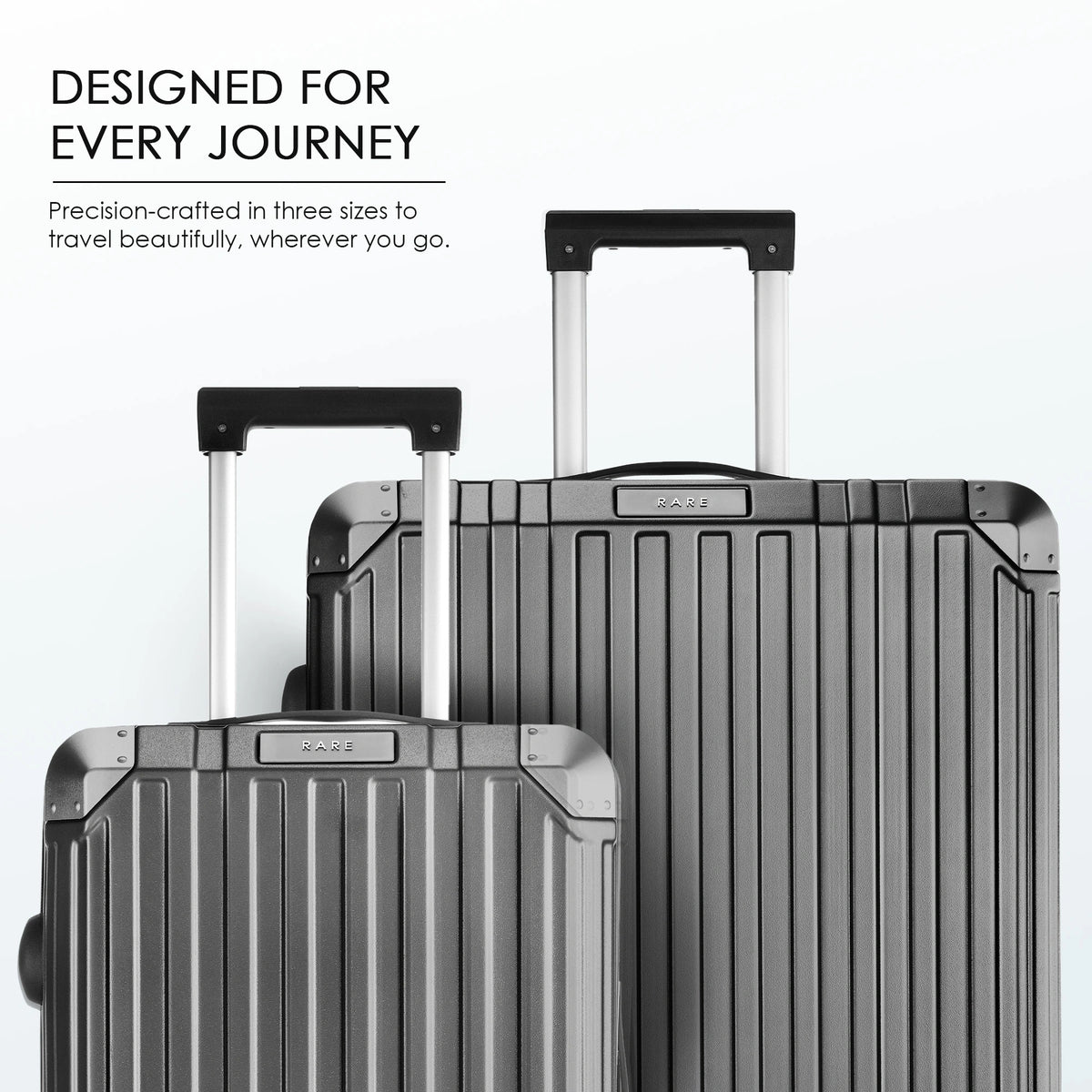 Stacked charcoal grey hard-shell suitcases with telescopic handles, three sizes shown