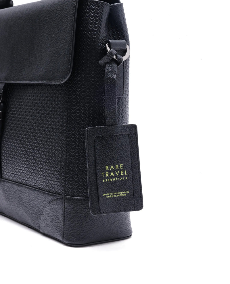 Black leather briefcase side view with front flap and hanging luggage tag