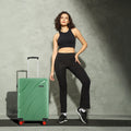Green hard-shell check-in suitcase with telescopic handle and red wheels