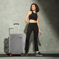 Grey hard-shell suitcase with 8 wheels and telescopic handle.