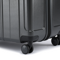 Dark grey rolling suitcase with corner handle and four caster wheels