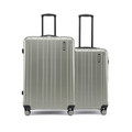 Two pale green hard-shell suitcases side by side with upright handles and wheels