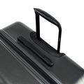 Hard-shell suitcase handle on ribbed shell, dark charcoal with black accents
