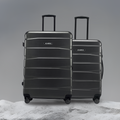 Hard body luggage set in dark/black with two upright wheeled suitcases and telescopic handles