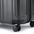 Grey check-in suitcase corner with lock cover and 360-degree spinner wheels.