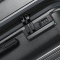 Grey check-in suitcase close-up of TSA-style lock panel and zipper track.