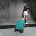 Teal small cabin suitcase with telescopic handle and 8 wheels, on the move.