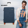Large check-in suitcase with dark blue ribbed shell and orange wheel accents