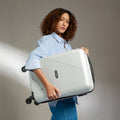 Light silver cabin suitcase with telescopic handle and 4 wheels, held upright