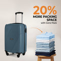 Teal cabin suitcase with top handle and 4 wheels, next to folded clothes stack.