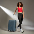 Blue hard-shell suitcase with telescopic handle and four wheels, upright position