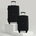 Hard-shell luggage set of 2 in black with telescopic handles and 4 wheels, stacked front view.