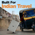 Hard-shell light gray luggage trolley with telescopic handle and four wheels, front-left view