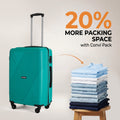 Medium teal hard-shell suitcase with telescopic handle and four wheels, beside folded clothes.