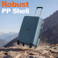 HRX medium polypropylene suitcase in teal on rocky ground with extended handle