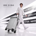 Light grey large check-in trolley with 8 wheels, carried upright by a traveler