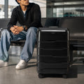 Black medium check-in trolley with telescopic handle and smooth-rolling wheels