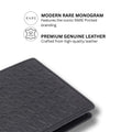 Leather bi-fold wallet corner close-up with embossed woven-style monogram pattern.