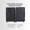 Hard-shell trolley suitcase open with divided packing pockets and adjustable cross-ribbon system, dark