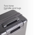 Hard-shell trolley suitcase top corner detail with two-tone handle and recessed zip channel, dark grey