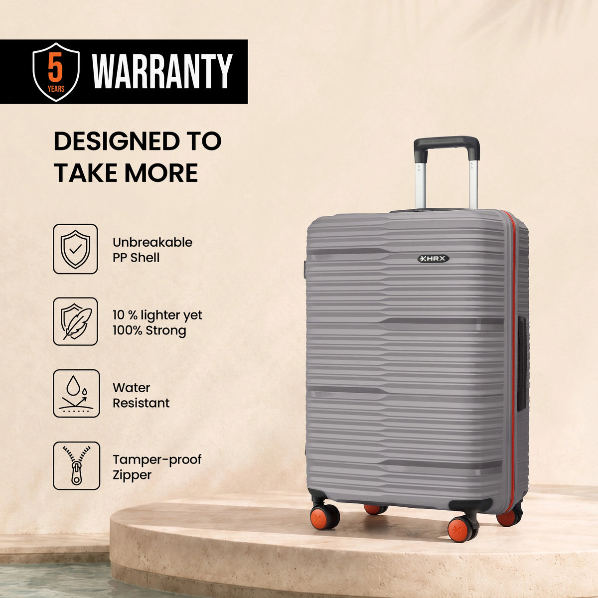 Grey polypropylene check-in suitcase with extendable trolley handle and orange wheels