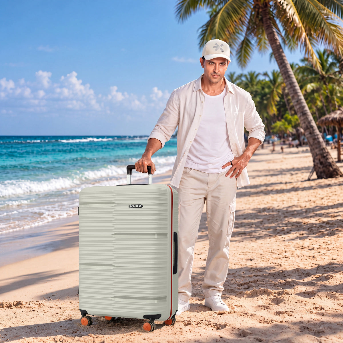 Light-colored hard-shell 8-wheel spinner trolley suitcase standing on sand