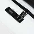 Black TSA-style combination lock and zipper pull on a white suitcase