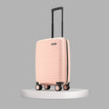 Peach small cabin suitcase on platform with telescopic handle and four wheels
