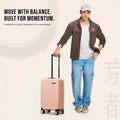 Peach polypropylene cabin suitcase with telescopic handle held while walking