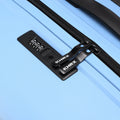 Light blue hard-shell suitcase with zip pull, crosshatch straps, and HRX label
