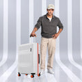 Large polycarbonate check-in suitcase, white with orange trim, upright on spinner wheels
