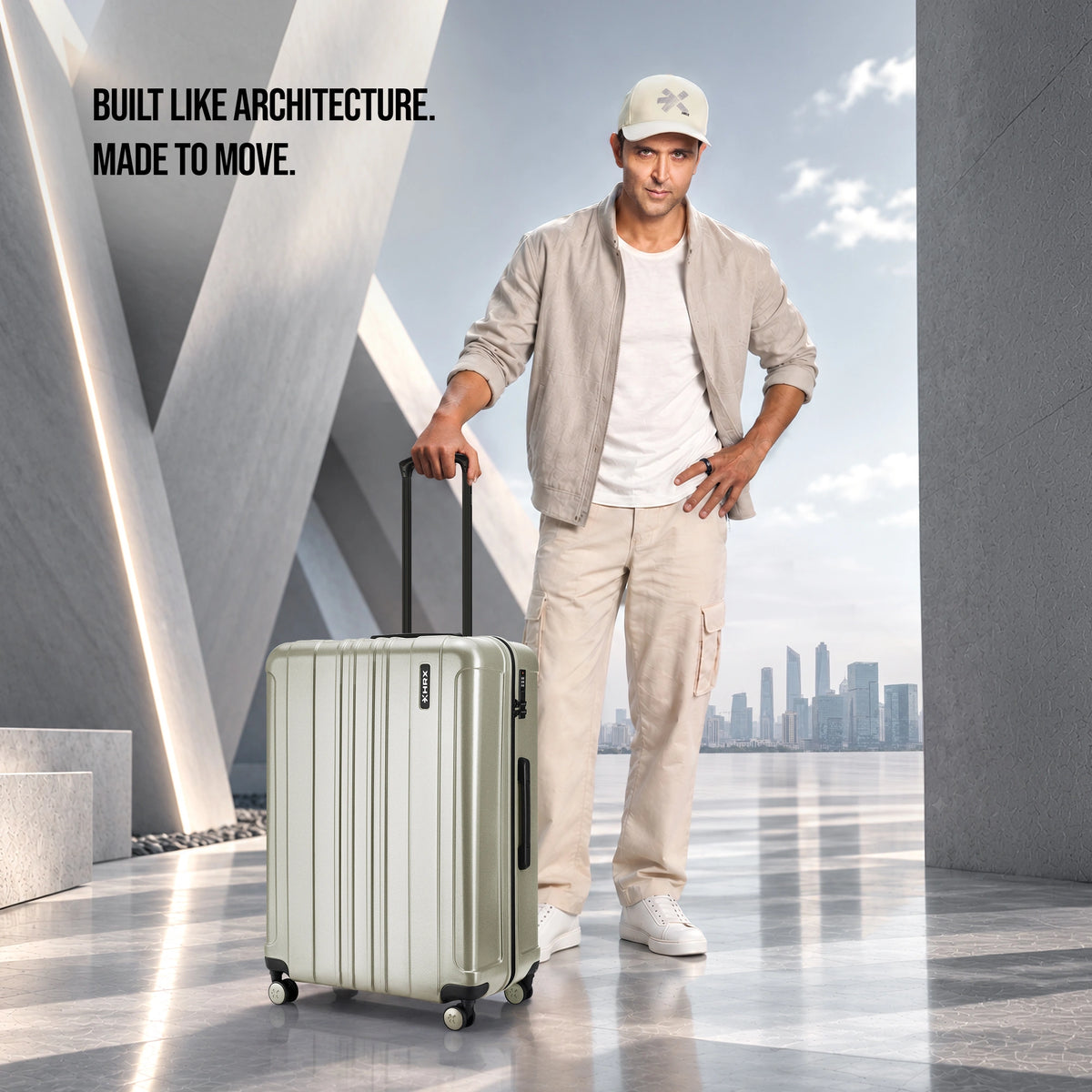 Silver check-in suitcase with upright handle and spinner wheels, shown with traveler