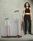 Two grey hard-shell rolling suitcases with telescopic handles and red-accent wheels