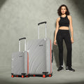Two grey hard-shell rolling suitcases with telescopic handles and red-accent wheels