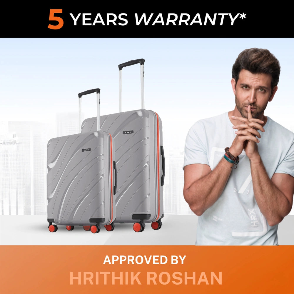Two grey hard-shell suitcases with telescopic handles, red trim, and spinner wheels