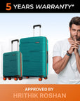 Teal hardshell cabin and large trolley suitcases with telescopic handles and spinner wheels.