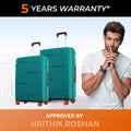 Pair of teal upright hard-shell suitcases with telescopic handles and orange wheels