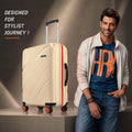 Cream medium check-in suitcase with upright handle, orange-trim wheels, and textured shell.